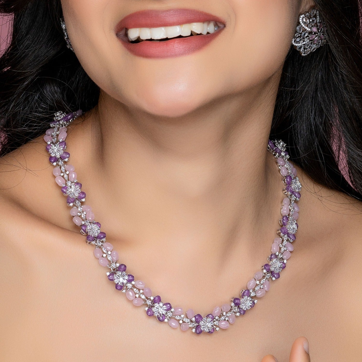 A picture of a necklace with Cubic Zirconia studded pink and lavender beads in a floral design.